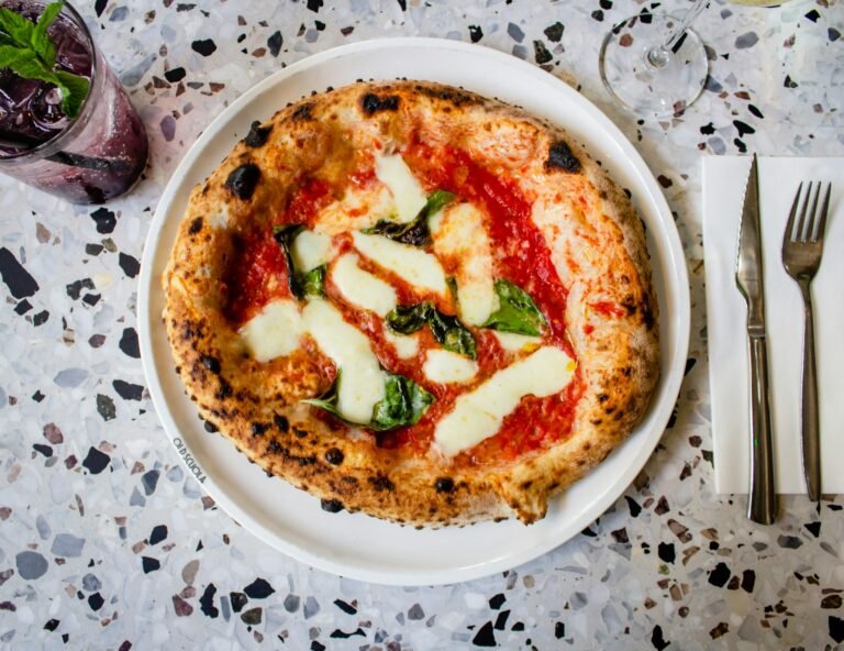 Classic Margherita pizza served on a plate as part of an Italian food travel guide