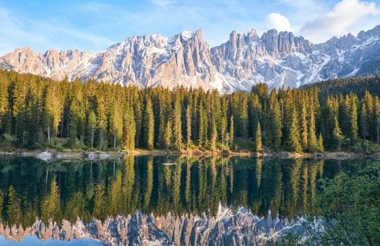 Scenic view of Karersee lake surrounded by mountains in Italy, perfect for outdoor adventure travel