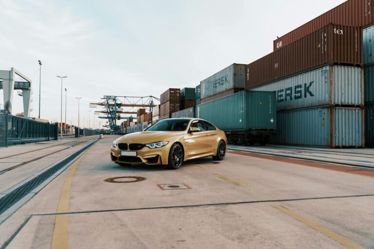 gold BMW next to a shipping container